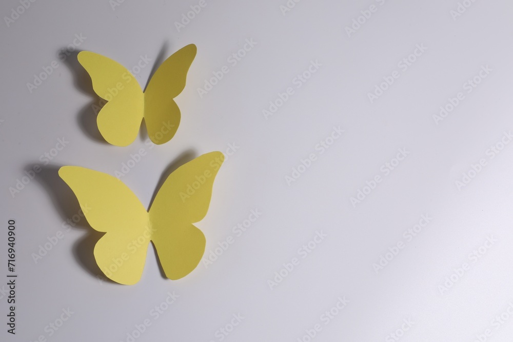 Canvas Prints Yellow paper butterflies on light background, top view. Space for text