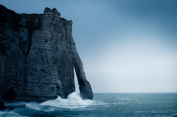 Chalk cliff in a storm in Normandy, France. Storm over the sea in Etretat. Porte d'aval of Étretat...
