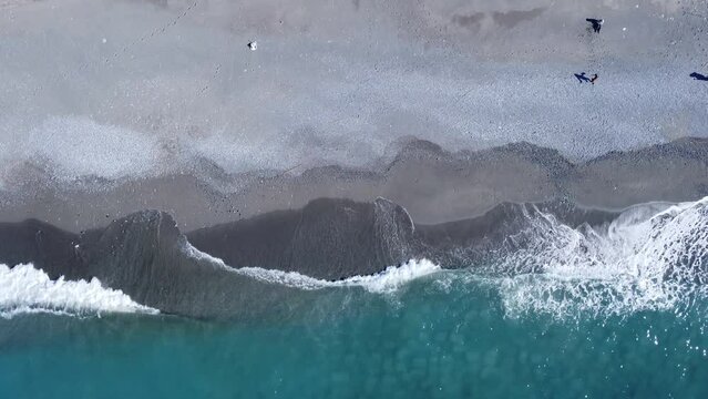 Overhead photo of crashing waves on the shoreline beach. Tropical beach surf. Abstract aerial ocean view