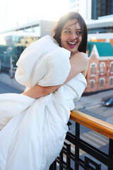 Portrait of smiling beautiful woman with white blanket