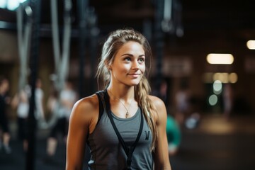 Portrait of a handsome girl in her 20s practicing rope climb in a gym. With generative AI technology