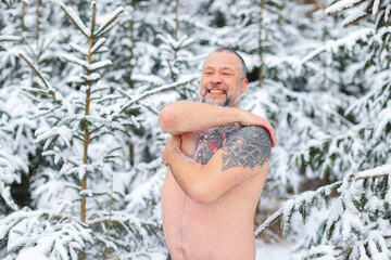 Winter tempering procedures. Naked man in the snow. Guy in snow showers for the hardening of the body. Winter healthy lifestyle.