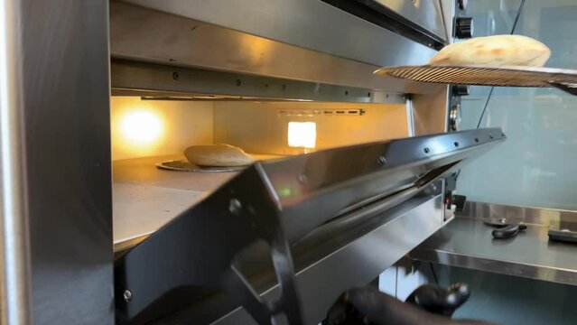 Chef takes out the finished pita bread from the oven, slow motion 4K
