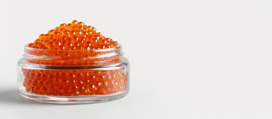 Glass jar containing tasty red caviar against white backdrop