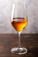 Glass of amber-colored sherry wine on wooden surface