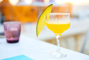 Glass of mango cocktail on bar counter