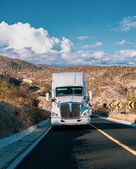 Cargo truck with cargo trailer driving on a highway. White truck delivering products.