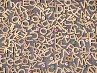 artistic arrangement of letters against a grey background creating a visual representation of alphabet soup. The letters are scattered randomly, offering a sense of disarray yet potential for creation