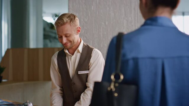 Hotel concierge assisting clients on arrival closeup. Smiling professional work