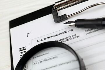 German annual income tax return declaration form blank on A4 tablet lies on office table with pen...