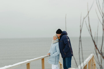 Portrait of an elegant elderly couple on a winter snowy day by the sea