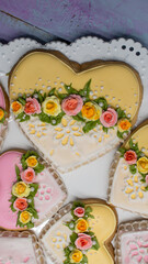 Romantic heart cookies decorated with royal icing roses, yellow and pink