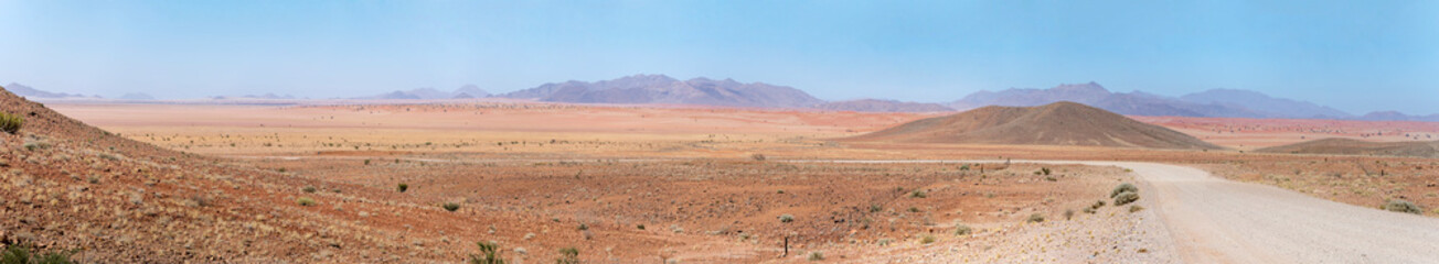 gravel road bending in colorful countryside of Naukluft desert, west of Betta, Namibia