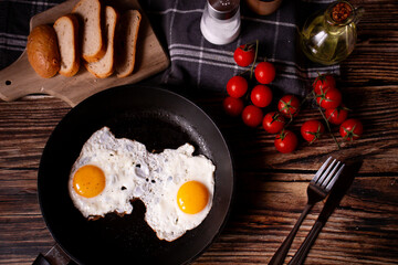 
Fried eggs in a pan. on a wooden background. Breakfast