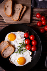 
Fried eggs in a pan. on a wooden background. Breakfast