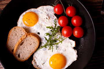 
Fried eggs in a pan. on a wooden background. Breakfast