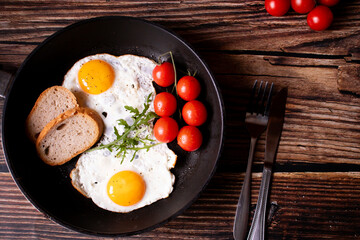 
Fried eggs in a pan. on a wooden background. Breakfast