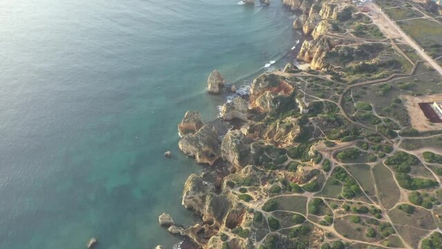 Aerial view of golden coast cliffs of portuguese southern beaches in Lagos City, Algarve, Portugal