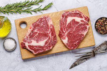 Raw ribeye steaks with savory spices