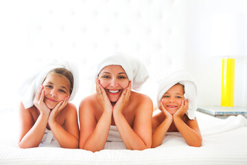 Mother and girls in bathrobes in room after shower