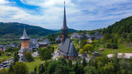 Fototapeta na wymiar Aerial photography of Barsana monastery located in Maramures County, Romania. The landscape photography was taken from a drone at a lower altitude with the beautiful wooden monastery in the view.