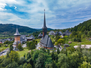 Fototapeta na wymiar Aerial photography of Barsana monastery located in Maramures County, Romania. The landscape photography was taken from a drone at a higher altitude with the beautiful wooden monastery in the view.