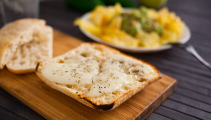 Toasted slices of square bread with warm cheese and and provencal herbs on plate breakfast
