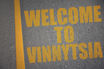asphalt road with text welcome to Vinnytsia near yellow line.