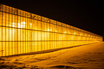 view of the greenhouse from the outside, all shining against the backdrop of snow and frosty night,...