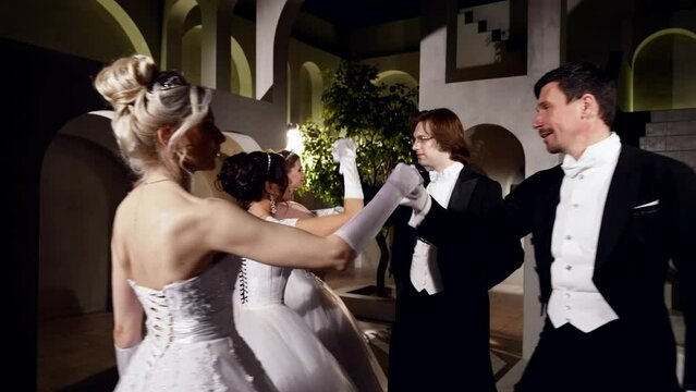 professional dancers performing traditional waltz dance in ballroom of royal palace in night