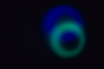 Elliptical shape of bright blue and cyan blurry lights with dark holes on a black backdrop