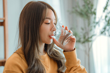 Asian woman drink water start new day with healthy life habit, Female holding glass drinking clean...