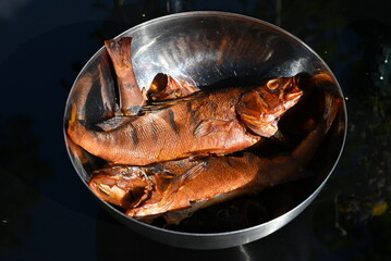Smoked fish in smokehouse box. Hot smoked river bass fish cooked with your own hands in a mini...