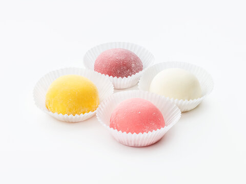 Mochi, 4 pieces of different colors; pink, white and yellow on a white background in paper forms. Side and top view.