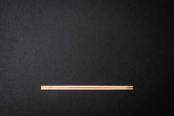 Light wooden chopsticks on a blank background as a backdrop for an Asian dish