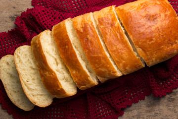 Artisanal, homemade bread, natural ingredients, natural fermentation, with red crochet cloth and wooden table, horizontal photo, to