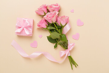 Pink roses with hearts and gift box on color background, top view. Valentines day concept
