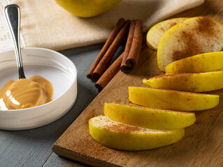 Sliced green apple with cinnamon and peanut butter