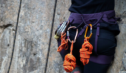 Girl is climbing in the mountains with a rope.