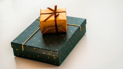 Green and gold wrapped gifts in a stylish design on a light surface closeup.