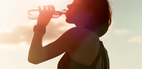 Girl drinks water from a bottle during her training.