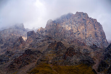 A beautiful rocky mounains in a foggy cloudy weather in the evening.