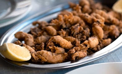 A plate with fried small delicious cuttlefish, grilled seafood closeup.