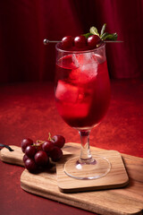 glass of cherry juice with fresh red grapes