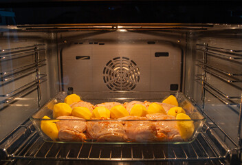 chicken thighs with potatoes baked in the oven on the grill close-up