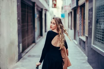Fotobehang Chica joven con pelo rizado posando en la calle © MiguelAngelJunquera