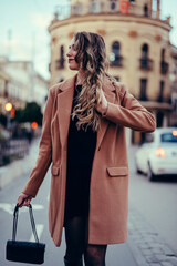 Chica joven con pelo rizado posando en la calle