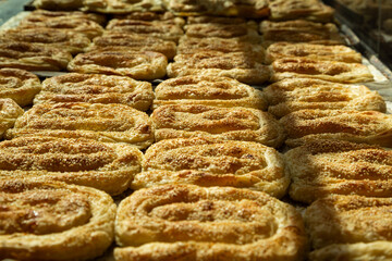 Close-up of golden-baked sesame seed pastries, fresh from the oven, ideal for bakery or culinary themes