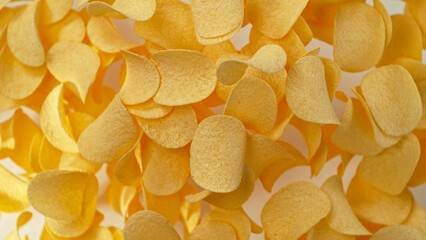 Freeze motion of flying fried potatoes chips on white background