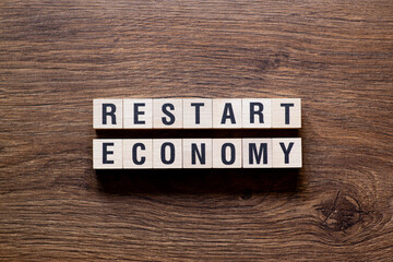 Restart economy - word concept on building blocks, text